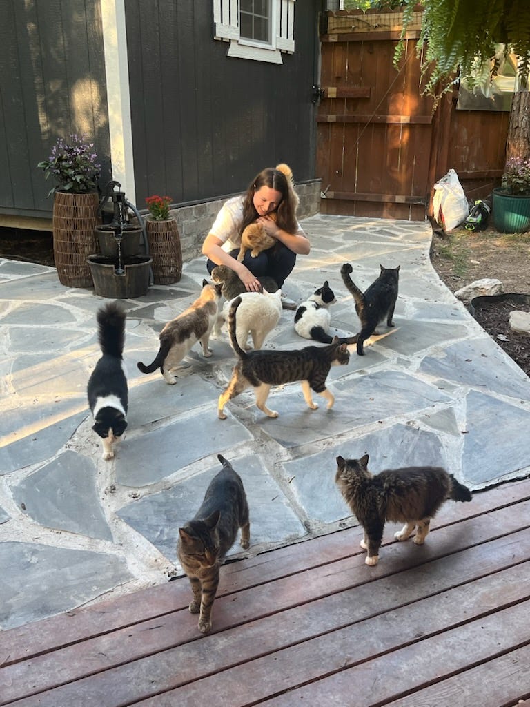 Carly with the rescue cats in the backyard